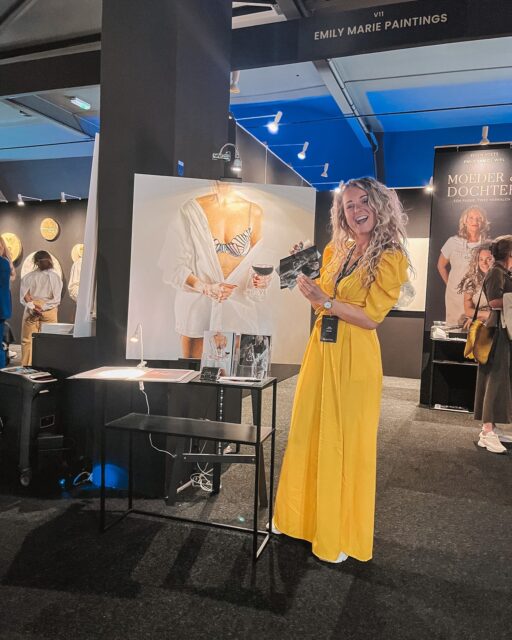 Terug naar vorig jaar… 🤍

Als ik denk aan de @theartofliving.online  van vorig jaar, voel ik vooral één ding: trots.

Trots omdat ik daar stond met mijn werk.
Niet alleen op mijn socials. Niet alleen in mijn atelier.
Maar gewoon… in het echt. Groot. Aan de muur.

Ik zit normaal uren alleen te schilderen. Dat is mijn wereld. Stil. Geconcentreerd. In mijn hoofd. En dan ineens sta je daar drie dagen tussen mensen die blijven staan. Die dichterbij komen. Die vragen stellen.

“Is dit écht geschilderd?”
“Dit is geen foto toch?”
“Hoe lang doe je hier over?”

En dan zie je die verbazing. Dat moment dat iemand het pas echt ziet.

Dat vond ik misschien wel het bijzonderste. Dat ik zelf bijna vergeet hoe speciaal het is wat ik maak, omdat het voor mij zo vanzelfsprekend voelt. Totdat iemand anders je dat teruggeeft.

Er was zelfs een dame die emotioneel werd bij één van mijn werken. Dat moment vergeet ik niet snel. Dan besef je: dit is meer dan verf op doek.

En het mooie is… sommige mensen die ik daar ontmoette, zijn later teruggekomen. Hebben me nog een bericht gestuurd. Of zelfs een schilderij gekocht.

Zo’n beurs stopt niet na dat weekend.

En daarom doe ik weer mee.

15, 16 en 17 mei sta ik er weer. Met nieuw werk. Nieuwe energie. En hopelijk weer net zulke mooie momenten.

Ik heb er zin in 🤍

—
Wie ben ik?
Emily van de Wiel

Ik ben kunstenares, gespecialiseerd in hyperrealistische schilderijen die vrouwelijke kracht en kwetsbaarheid vangen. Mijn werk draait om detail, licht en intimiteit. Vaak persoonlijk, soms rauw, maar altijd echt. Ik maak zowel vrij werk als schilderijen in opdracht, ieder doek met liefde en precisie geschilderd.

Laten we connecten!